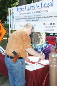 Bill Starks arranges materials on the Open Carry information table