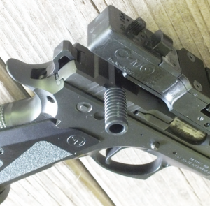 The charging handle that fits in the rear sight slot eliminates the problem of charging a scoped pistol