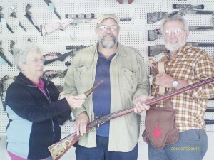 Judy and Anson Morgan present Jim Fulmer (center) his prizes from Michigan State Muzzleloaders annual give-a-way.