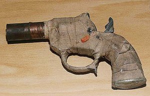 (Connecticut State) An interesting design, this .22 caliber zip gun, built by two high school boys, was seized during an attempt to smuggle it to a relative housed in a CT state prison. It is a cap gun with a pipe barrel, strong rubber band to power the striker and bound with medical tape. 