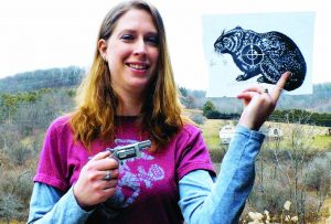 Heidi Conti, an executive with Conti Industries and Black Ops Tactical, holds her groundhog test target in one hand and her personal Sidewinder in the other during a 2015 range outing. (J. David Truby photo)