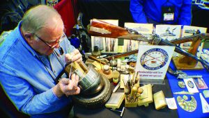 Master Engraver John Schippers demonstrating engraving at the NMLRA booth at the NRA convention.