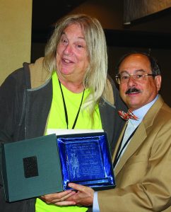 Alan M. Gottlieb (right) presents the Grasroots Activist of the Year Award to Nikki Stallard of the Pink Pistols at the 2016 GRPC Awards Luncheon.