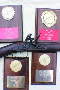 Author’s new .32 cal. rifle with old trophies won when he was State Team Captain.