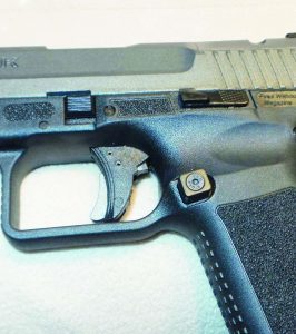 Canik relieves the rear of the trigger guard to allow for a higher grip which reduces felt recoil. You can also see the extended magazine release, slide stop and takedown lock in this photo.