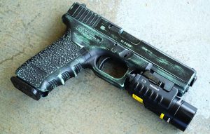 The author deploys a TruGlo TruPoint combination light/laser with the Glock Model 22C. 