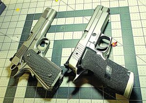 A pair of well-traveled stainless pistols, Springfield Armory 1911 and Sig Sauer X5 awaiting a new look.